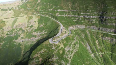 Car-drive-sharp-hairpin-turn-in-steep-Madeira-mountain-hillside