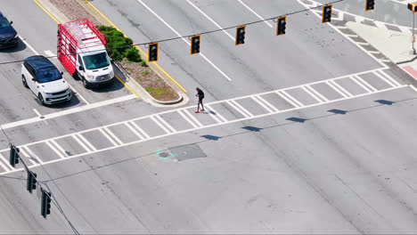 Slow-motion-top-down-of-pedestrian-at-crosswalk-and-large-junction-in-american-town
