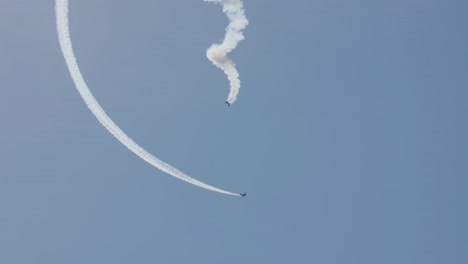 Two-stunt-planes,-one-in-a-spiral-stall,-and-one-circling-around-it