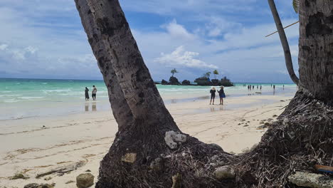 Boracay,-Philippines,-People-on-Sand-of-White-Beach-and-Willy's-Rock,-Island's-Landmark