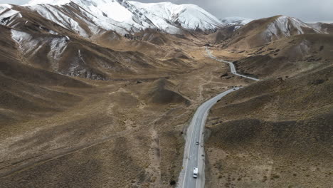 Cars-driving-along-the-highway-in-the-Lindis-Pass-region-on-the-South-Island,-New-Zealand