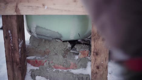 The-Man-is-Using-Small-Rocks-and-Cement-to-Fill-the-Gaps-Beneath-the-DIY-Hot-Tub---Close-Up