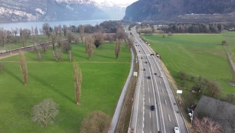 Swiss-highway-cuts-through-pastoral-landscape---aerial-fly-over