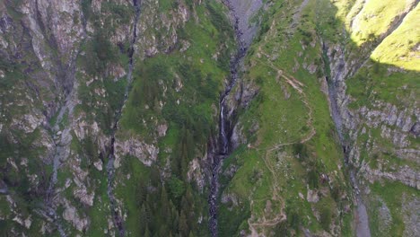 Vibrant-shot-of-Valea-Rea-Waterfall-cascading-down-in-Fagaras-Mountains-at-sunrise,-lush-greenery-surrounds