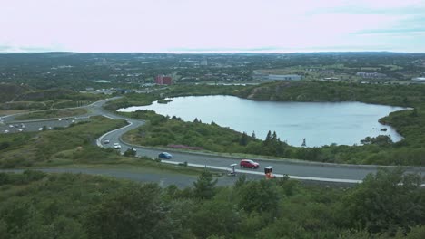 On-top-of-signal-hill-looking-down-at-Georges-pond-in-Newfoundland-as-cars-drive-by