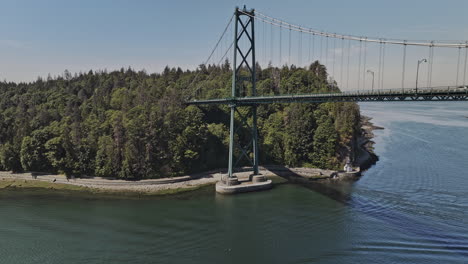 Vancouver-BC-Canadá-Drone-Aéreo-V105-Vuela-Bajo-El-Puente-Lions-Gate,-Capturando-El-Oasis-Urbano-Del-Parque-Stanley-Y-El-Paisaje-Urbano-Con-Un-Barco-Navegando-En-El-Agua---Filmado-Con-Mavic-3-Pro-Cine---Julio-De-2023