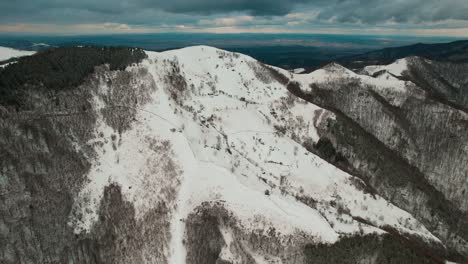 Vista-Aérea-Invernal-De-Montañas-Cindrel-Con-Picos-Y-Bosques-Cubiertos-De-Nieve