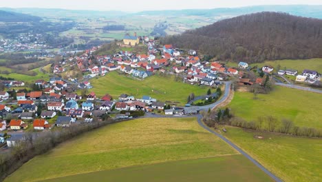 Ruhige-Luftaufnahme-Einer-Kleinen-Stadt-Mit-Schloss-Auf-Dem-Land