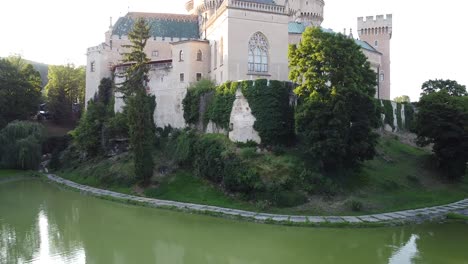 Revealing-shot-from-water-of-Gothic-12th-century-Meddieval-castle-with-moat-walls-in-Bojnice-Slovakia-Europe