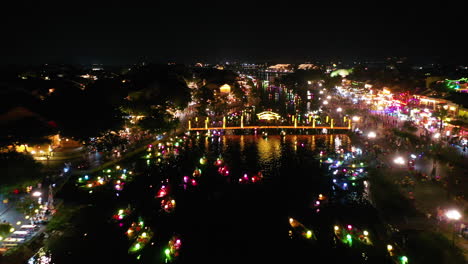 Aerial-view-of-colorful-lantern-boats-dotting-the-river-at-night-in-Hoi-An,-Vietnam