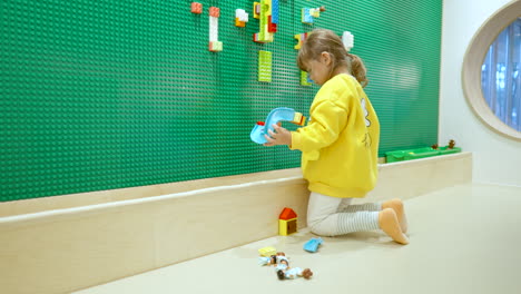 Ukrainian-Korean-toddler-playing-with-educational-toys-at-indoor-playground