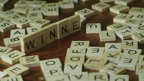 Cerrar-Letras-De-Mosaicos-De-Scrabble-En-El-Borde-Hacer-Palabra-Ganador-En-La-Mesa