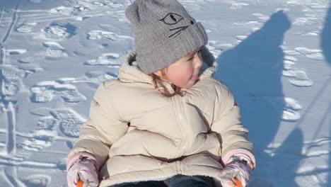 Aufgeregtes-Mädchen-Genießt-Rodeln-Im-Plastikschlitten-Auf-Schnee-Bei-Sonnenuntergang,-Gezogen-Vom-Vater