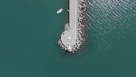 Draufsicht-Auf-Den-Wunderschönen-Leuchtturm-Am-Felsigen-Yachthafen-Mit-Einem-Kleinen-Boot