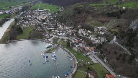 Dynamic-aerial-ascend-establishes-pier-or-dock-with-small-boats-to-explore-swiss-lake