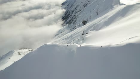 Schneebedeckte-Piatra-Craiului-Berge-Mit-Wanderern-In-Der-Ferne,-Umgeben-Von-Wolken,-Vermitteln-Ein-Gefühl-Von-Abenteuer