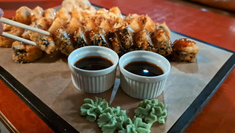 Varios-Tipos-De-Sushi-En-El-Plato,-Intento-De-Selección-De-Palillos-Para-Evitar-El-Hambre,-Plato-Listo-Con-Salsa-De-Soja-Y-Wasabi.