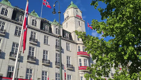 Grand-Hotel-Oslo,-Edificio-Antiguo-Y-Hotel-De-5-Estrellas-En-El-Centro-Decorado-Con-Banderas-Nacionales-Noruegas