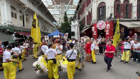 Szene-Einer-Löwentanzgruppe,-Die-Vor-Der-Aufführung-In-Chinatown,-Singapur,-Willkommensgrüße-Ausspricht