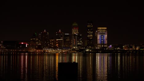 Skyline-Von-Louisville,-Kentucky-Mit-Ohio-River-Bei-Nacht-Und-Boot-In-Bewegung-Mit-Stabiler-Totalaufnahme