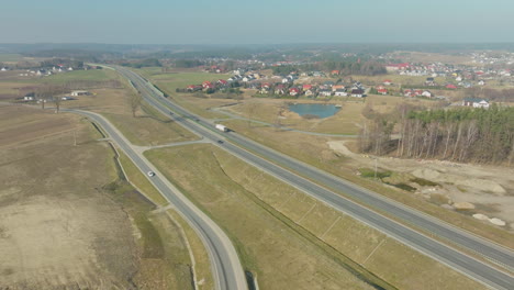 Aerial-view-of-a-highway-through-a-rural-area-with-houses