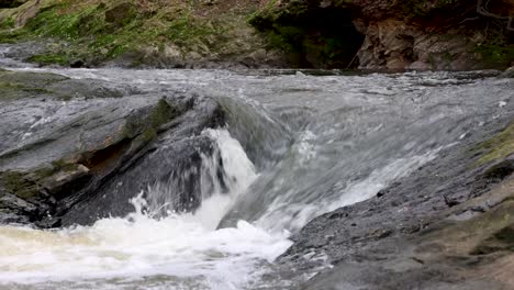 Water-rushing-over-and-around-rocks-in-a-small-stream-or-river