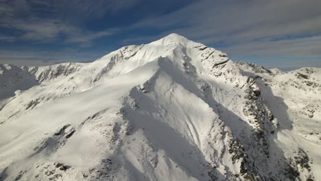 Pico-Lespezi-En-Las-Montañas-Fagaras-Bajo-Un-Cielo-Azul-Claro,-Paisaje-Nevado,-Vista-Aérea