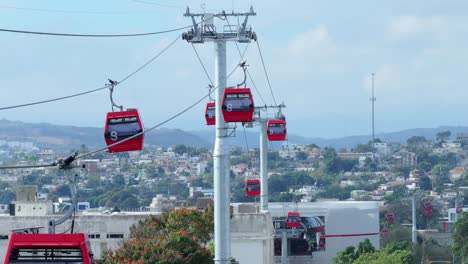 Red-Cable-Cars-in-motion-over-SANTIAGO-DE-LOS-CABALLEROS-City-during-cloudy-day,-Dominican-Republic