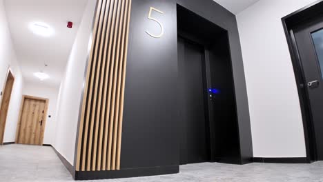 Eingang-Zu-Einem-Modernen-Schwarzen-Aufzug-Mit-Holzverzierungen