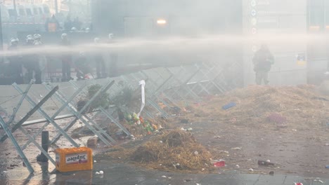 La-Policía-Antidisturbios-Belga-Protege-El-Edificio-Del-Parlamento-De-La-UE-Con-La-Manguera-De-Agua-Durante-Una-Manifestación-De-Agricultores-Enojados-En-Bruselas,-Bélgica