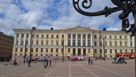 Edificio-Principal-De-La-Universidad-De-Helsinki-Y-Gente-En-La-Plaza-Del-Senado-En-Un-Día-Soleado,-Finlandia