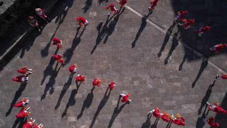 Majorette-Girls-in-Red-Uniforms-on-Performance-During-Festival,-Top-Down-Aerial-View