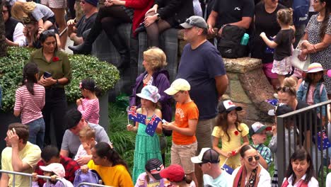 Families-from-across-generations-gather-with-anticipation-along-the-streets,-eagerly-awaiting-the-commencement-of-the-annual-Anzac-Day-parade-tradition,-close-up-shot