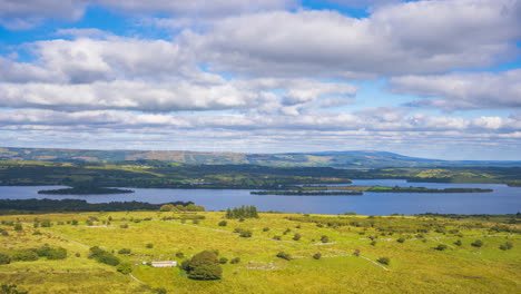 Zeitraffer-Von-Ländlichem-Ackerland-Mit-Windrädern-In-Hügeln-Und-See-In-Der-Ferne-Während-Eines-Sonnigen,-Bewölkten-Tages,-Gesehen-Von-Carrowkeel-In-Der-Grafschaft-Sligo-In-Irland