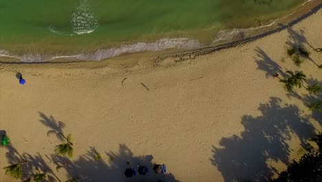 Descending-overhead-drone-shot-of-the-beachfront-of-Miami-showing-the-surging-waves-of-the-Ionian-Sea-hitting-the-coast-of-Itea,-in-Central-Greece