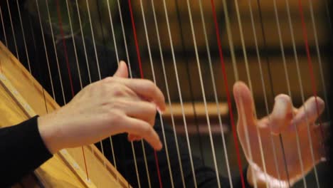 Woman's-hands-playing-the-harp-as-part-of-a-symphony