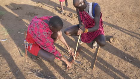 Zwei-Massai-Krieger-Verwenden-Die-Reibungstechnik,-Um-Das-Feuer-Zu-Entfachen