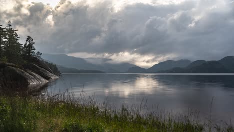 Oscuras-Nubes-Tormentosas-Giran-Sobre-El-Lago-Con-Bancos-Rocosos-Y-Montañas