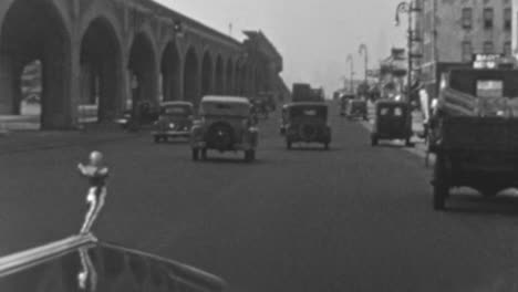 Oldtimer-Fahren-Durch-Die-Straßen-Neben-Einer-Stadtbrücke-In-Den-1930er-Jahren