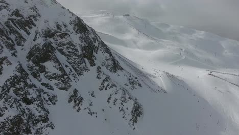 Eine-4K-Drohne-Mit-Vorwärtsbewegung-Schoss-über-Backcountry-Snowboarder,-Die-Das-Extreme-Gelände-Der-„East-Wall“-Hinaufwandern,-Die-über-Dem-Skigebiet-Arapahoe-Basin-In-Den-Rocky-Mountains-Von-Colorado-Aufragt.