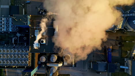 Top-aerial-view-of-fumes-coming-from-an-industrial-chimney-near-a-residential-area