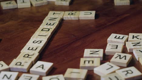 Fingers-move-Scrabble-letter-tiles-to-form-words-PRESIDENT-and-TRUMP