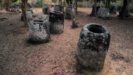 Plain-of-Jars,-Drone-fly-through-jungle-closeup-to-megalithic-structures