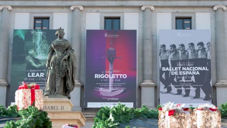 Blick-Auf-Die-Statue-Von-Isabel-II.-Im-Vordergrund-Vor-Dem-Teatro-Real,-Spaniens-Bedeutendster-Institution-Für-Darstellende-Und-Musikalische-Künste,-Auf-Der-Plaza-Isabel-II-In-Spanien