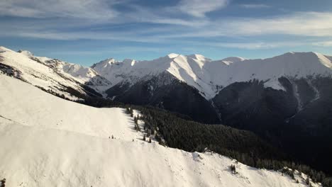 Montañas-Fagaras-Bañadas-Por-El-Sol-Bajo-Un-Cielo-Azul-Con-Picos-Cubiertos-De-Nieve-Y-Pinos