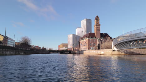 Niedrige-Antenne-über-Dem-Kanal-Vorbei-An-Der-Fußgängerbrücke-In-Richtung-Gebäude-Der-World-Maritime-University