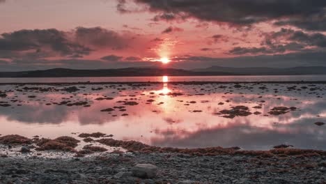 Feurig-Roter-Sonnenuntergang-Und-Dunkle-Wolken-Spiegeln-Sich-Im-Ruhigen-Fjordwasser