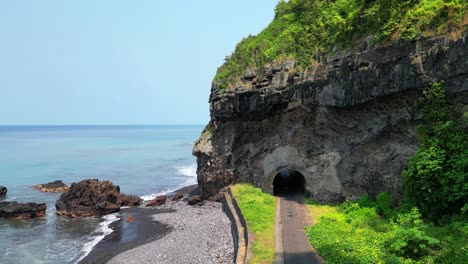 Aerial-view-of-Santa-Catarina-tunnel-with-a-kid-on-a-bike-in-Sao-Tome,Africa
