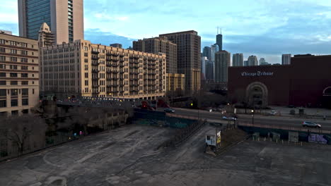 Aerial-view-rising-in-front-of-the-Chicago-Tribune,-revealing-the-city-skyline,-during-sunset