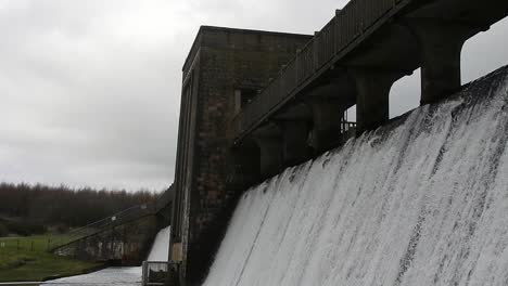 Llyn-Cefni-reservoir-concrete-dam-gate-pouring-from-Llangefni-lagoon,-Anglesey-rural-scene-close-up